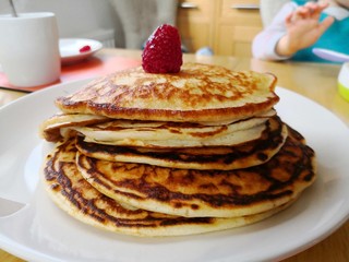 stack of American style pancakes with a raspberry on top