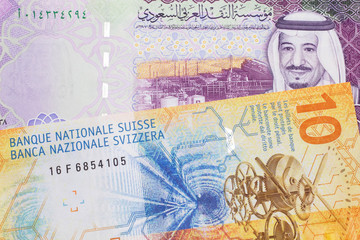 A yellow, ten Swiss franc note with a five Saudi riyal bank note from Saudi Arabia's central bank