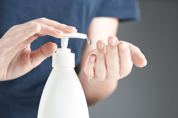 Female hands using hand sanitizer gel pump dispenser. A drop of gel close-up.
