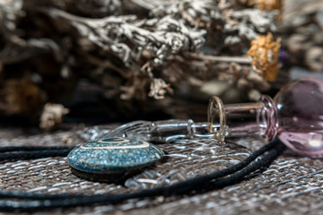 Set for witches. An overturned medicine bottle, a magic stone, and dried herbs.
