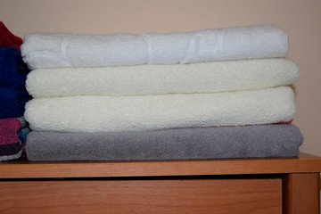 White terry towels neatly folded on the dresser.