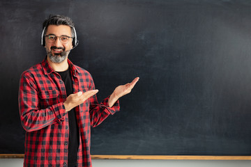 Adult man teacher pointing empty blackboard.