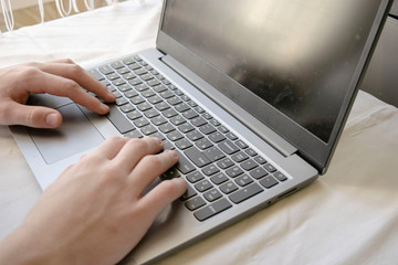 young man student working with laptop computer at home , lifestyle concept, stay at home during the Covid-19 coronavirus pandemic.