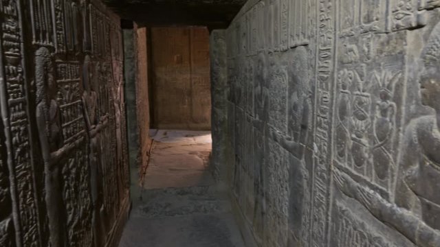 Hieroglyphic drawings and carvings on the wall of the dark corridor of the ancient Egyptian tomb, panorama 4k