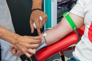 Blood donor at donation, transfusion. Insertion of a needle into a vein.