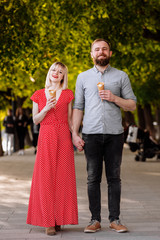 Couple hugging and eating ice cream on street. Tourist couple sharing ice cream outdoors and smiling. A picture of a lovely couple eating ice-cream.