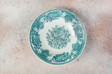 Antique porcelain dish on concrete background.