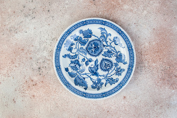 Antique porcelain dish on concrete background.