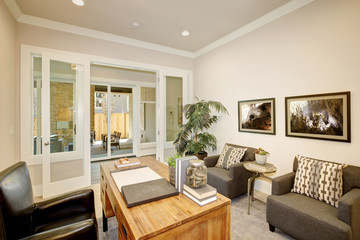 Light home office features a wooden desk. Luxury American modern home.