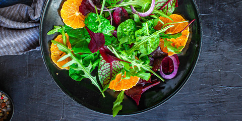 healthy salad tangerines citrus, lettuce, arugula and other herbs. Menu concept food background, keto or paleo diet. top view. copy space for text