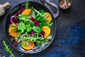 healthy salad tangerines citrus, lettuce, arugula and other herbs. Menu concept food background, keto or paleo diet. top view. copy space for text