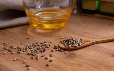 Dietary organic hemp seeds in a wooden spoon on a wooden background. Raw oil for proper nutrition....