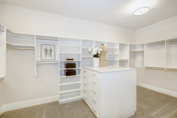 Fototapeta na wymiar Huge walk-in closet with shelves, drawers and clothes rails. Luxury American modern home.