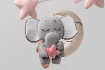 Baby crib mobile - kids toys, on light background.