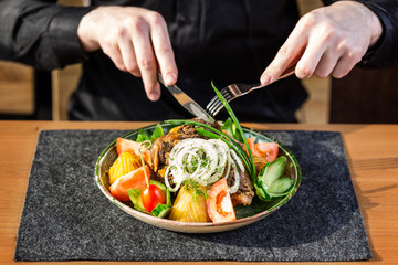 Kazan kebab on plate. Men's hands with cutlery