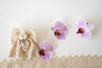 Angel, pink orchids and lace on white background