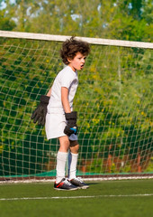 Summer soccer tournament for young kids. football club. emotions and joy of the game. Young goalie. Kids - soccer champion. Boy goalkeeper in football sportswear on stadium with ball. Sport concept.