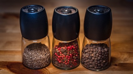 Pepper mills kitchenware on the wooden background