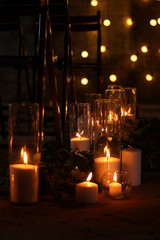 Night and bokeh. On a dark background a lot of candles are burning. Loft romantic atmosphere