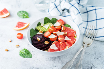 Red grapefruit beet spinach tomato salad in a bowl