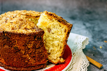 Panettone delicious christmas italian traditional cupcake closeup. Sliced cupcake with pieces of dried fruit on a dark background, copy space