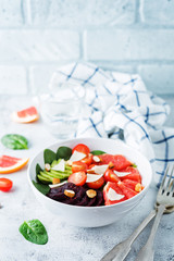 Red grapefruit beet spinach tomato salad in a bowl