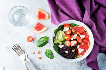 Red grapefruit beet spinach tomato salad in a bowl