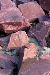 Natural background with red chipped stones. Red crushed stone on the ground close-up.