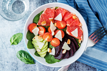 Red grapefruit beet spinach tomato salad in a bowl