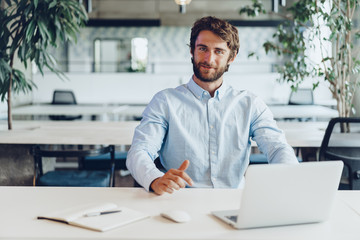 Obraz premium Businessman in shirt working on his laptop in an office. Open space office