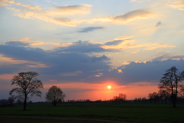Fototapeta na wymiar Kolorowy zachód słońca nad obszarem wiejskim, kolorowe chmury.