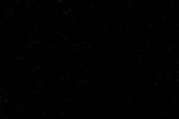 The spring dark, night sky was covered with a lot of stars with a place for the inscription. Real photo. You can use it for drawing on a material, marble tiles, or texture.