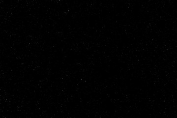 The spring dark, night sky was covered with a lot of stars with a place for the inscription. Real photo. You can use it for drawing on a material, marble tiles, or texture.