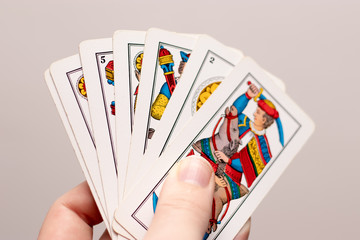 A hand holding several Italian old playing cards. Popular game in the mediterranean region, played in italy and croatia. Triestine version originating from northern italy