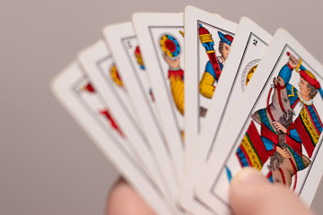 A hand holding several Italian old playing cards. Popular game in the mediterranean region, played in italy and croatia. Triestine version originating from northern italy