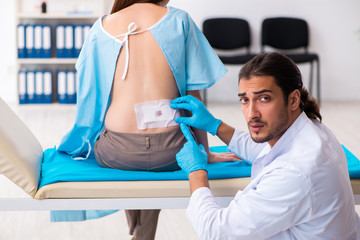 Injured young woman visiting young male doctor