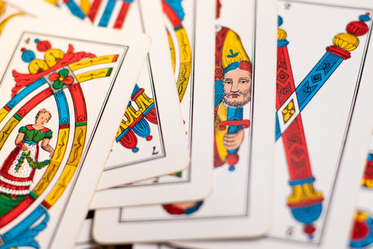 Triestine cards, old european game originating from northern italy laying on the wooden table. Flat lay on the table, multiple cards close up, bastoni, spade
