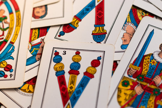 Triestine cards, old european game originating from northern italy laying on the wooden table. Flat lay on the table, multiple cards close up, bastoni, spade