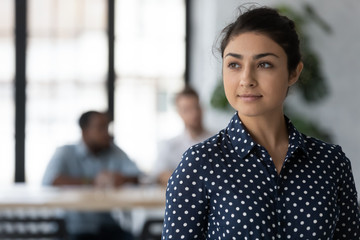 Dreamy young Indian female employee look in distance thinking or pondering, thoughtful happy millennial biracial woman worker plan consider future career opportunities, business vision concept - Powered by Adobe