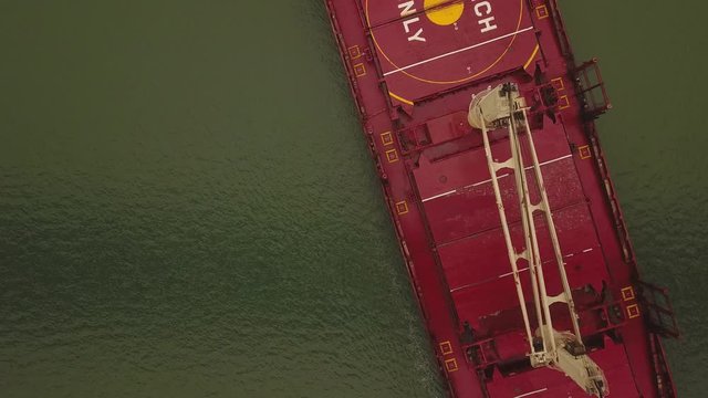 a flying camera takes pictures of a barge floating on a river,near,top down
