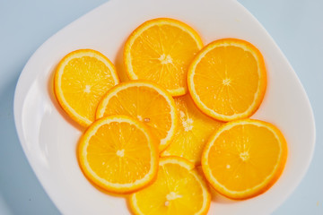 oranges on a white plate on a blue background