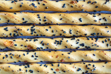 Traditional italian grissini bread sticks with black sesame seeds. National cuisine of Italy. Close-up.