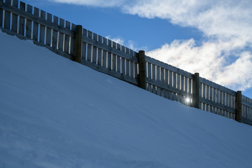 Texture of natural snow with fences. View above the snow.