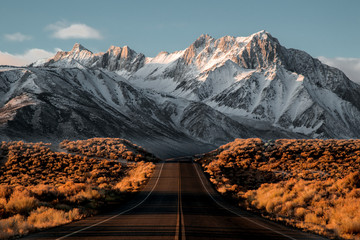 Blick auf die Straße in Richtung schneebedeckter Berge