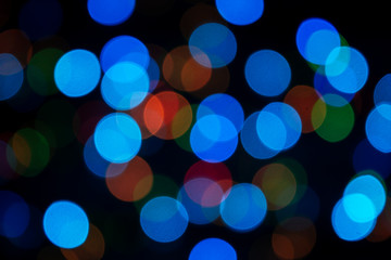 Multi-colored abstract bokeh on a black background. Blurred background