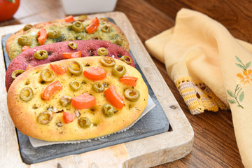 variety of different focaccia, with pumpkin, carrot and beet, on a rustic table