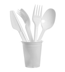 Plastic cutlery, knives, spoons and forks inside cup isolated on white background with clipping path