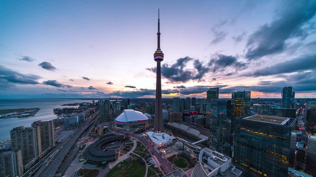 Day to night time lapse view of Toronto cityscape showing architectural landmark CN Tower and Downtown buildings in Toronto, Ontario, Canada.