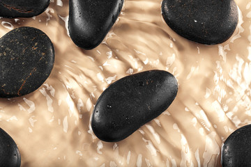 Massage spa stones close up in wavy water background