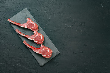 Raw fresh lamb ribs on dark background, close up.
